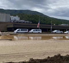 The flooded Baxter North Cove IV bag plant in North Carolina with its flags at half mast for the more than 250 people killed by Hurricane Helene, including at least one Baxter employee. Baxter photo