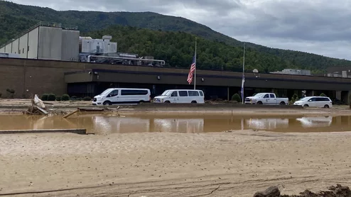 The flooded Baxter North Cove IV bag plant in North Carolina with its flags at half mast for the more than 250 people killed by Hurricane Helene, including at least one Baxter employee. Baxter photo