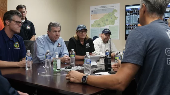 North Carolina Governor Roy Cooper, alomg with FEMA and state disaster recovery agency officials, get briefed by Mission Hospital CEO Greg Lowe on the impacts of the Hurricane Helene flooding on the main hospital in Ashville and what they need to continue operations. The hospital is operating, but is using water from trucks because the city water treatment facilities were damaged and contaminated during flooding. Photo North Carolina Governor's Office.