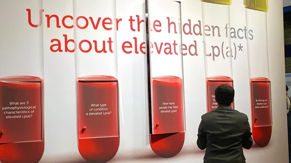 An attendee at AHA 2024 looking at educational displays on Lp(a) in the Novartis booth. Photo By Dave Fornell